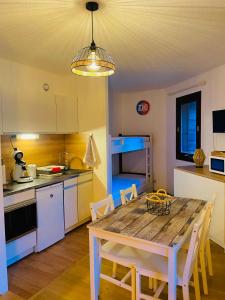 a kitchen with a wooden table and a dining room at Au Refuge d'Orres in Les Orres