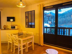 a dining room with a table and chairs and a window at Au Refuge d'Orres in Les Orres