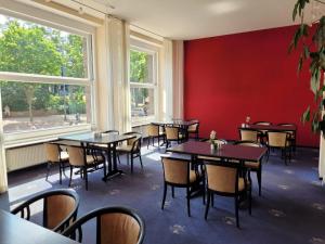 jadalnia ze stołami, krzesłami i oknami w obiekcie Hotel Schweizer Hof w mieście Halle (Saale)