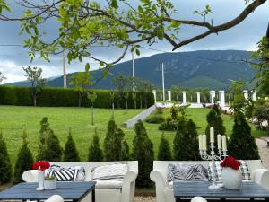 um pátio com sofás brancos e uma mesa com velas em Magnolia by Radovanovic em Petrovac na Mlavi