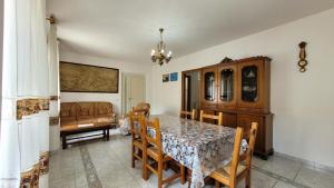 a dining room with a table and chairs and a couch at Mara's Home Holiday in Orosei