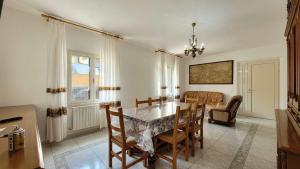 a dining room with a table and chairs and a couch at Mara's Home Holiday in Orosei