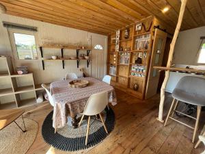 ein Esszimmer mit einem Tisch und Stühlen in einer Hütte in der Unterkunft SOCOA LE CABANON in Lacanau