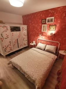 a bedroom with a bed and a red wall at Cosy 2 rooms apartment with a view near the forest in Predeal