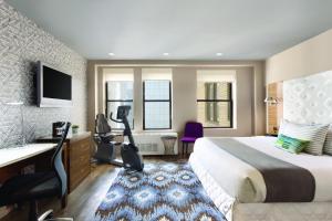 ein Hotelzimmer mit einem großen Bett und einem Schreibtisch in der Unterkunft The Gallivant Times Square in New York