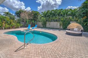 a swimming pool with two chairs in a yard at Relax Poolside & Walk or Bike to the Beach From This Amazing Naples Pool Home! in Naples