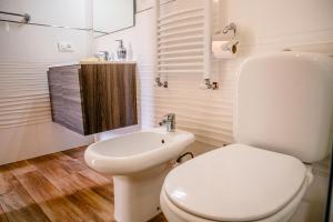 ein weißes Bad mit einem WC und einem Waschbecken in der Unterkunft House I Gabbiani in Levanto