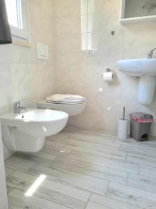 bagno bianco con servizi igienici e lavandino di Civico 14 Apartment 4B a Monserrato
