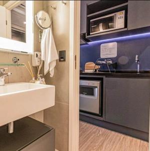 a kitchen with a sink and a microwave at AlphaStay by Rhouses in Barueri +157 photos