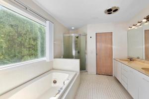 a bathroom with a tub and a sink and a window at Rosemorran Retreat in Sag Harbor