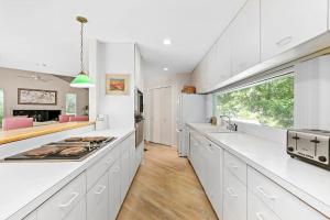 a kitchen with white cabinets and a large window at Rosemorran Retreat in Sag Harbor
