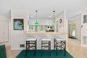 a kitchen with white walls and a counter with stools at Rosemorran Retreat in Sag Harbor