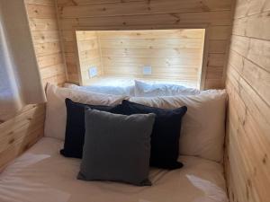 een bed in een houten kamer met 2 kussens bij Foundry Farm Arch in Bellingham
