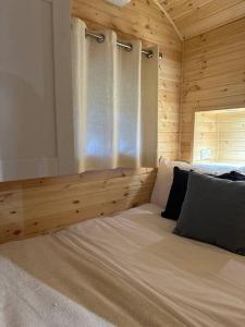 een bed in een houten kamer met een raam bij Foundry Farm Arch in Bellingham