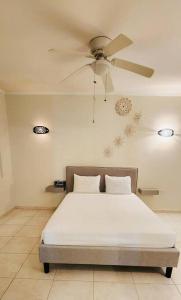 a bedroom with a bed with a ceiling fan at Dushi Apartment Near the Beach in Jan Thiel