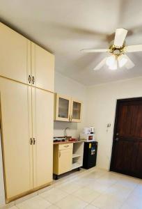 a room with a ceiling fan and a kitchen at Dushi Apartment Near the Beach in Jan Thiel