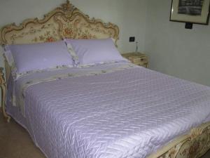ein Bett mit einer weißen Bettdecke und einem Tisch in der Unterkunft Appartamento per le vacanze ,, Villa Miky,, in Pairola