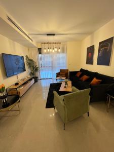 ein Wohnzimmer mit einem Sofa und einem TV in der Unterkunft Kineret sheli- 4Bedrooms luxury apartment with stunning lake view in Tiberias