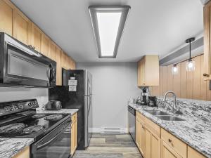 a kitchen with a sink and a stove top oven at CM325 Copper Mtn Inn condo in Copper Mountain