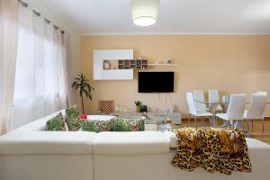 uma sala de estar com um sofá branco e uma mesa em Moradia Casa Feliz em Santa Cruz - Madeira