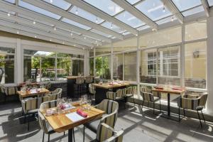 a restaurant with tables and chairs and windows at Hotel Indigo Napa Valley, an IHG Hotel in Napa