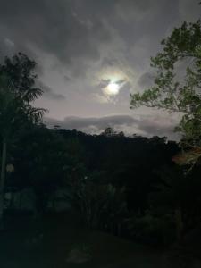 um céu nublado com o sol a espetar através das árvores em Pousada do Mirante em Viscode de Mauá
