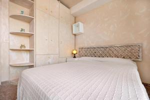 a bedroom with a white bed and shelves at Atico Altafulla in Altafulla