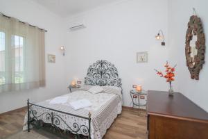 una camera da letto con un letto con copriletto bianco e nero di Maison Chloe a La Maddalena