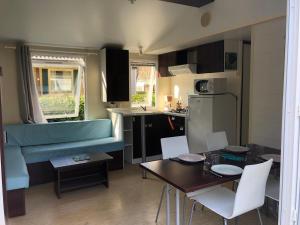 a kitchen and living room with a table and chairs at Mobilhome 3 chambres in Bias