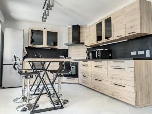 une cuisine avec des placards en bois et une table dans l'établissement Chambre Escapade - SDB WC Privatif - Entrée autonome - Grande TV NETFLIX, à Compiègne