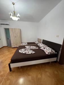 - une chambre avec un lit dans une pièce dotée d'un lustre dans l'établissement Apartment Kune, Shëngjin 2, à Shëngjin