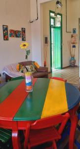a multicolored table with a vase on top of it at Hostel Recife Bar quartos climatizados das 22h às 6h in Recife