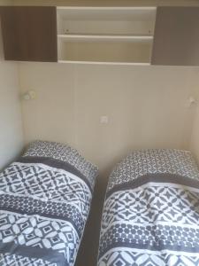 two beds in a room next to each other at Mobilhome 3 chambres in Bias