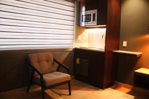 une chaise dans une chambre avec une fenêtre et un four micro-ondes dans l'établissement Hotel veinti 3 Tapachula, à Raymundo Enríquez