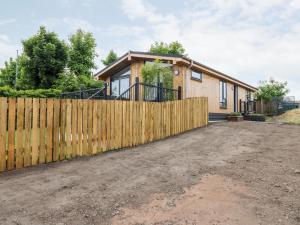 a wooden fence in front of a house at Eden Fields Lodge in Cupar