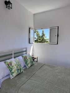 um quarto com uma cama com duas almofadas e uma janela em Villa Almagre em Gáldar
