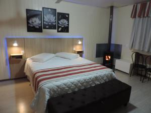 a bedroom with a large bed and a fireplace at Cabanas Brisa dos Canyons in Cambará