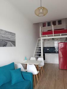 a living room with a couch and a table and bunk beds at Bala Beach Siófok Apartman in Siófok