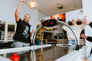 Un groupe de gens debout autour d'un comptoir avec les mains en l'air dans l'établissement Rotterdam Teleport Hotel, à Rotterdam