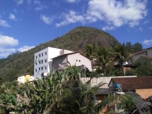 a mountain in the distance with a white building at QUARTO CASA FREDERICO in Domingos Martins