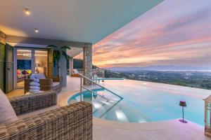 a swimming pool in a house with a sunset at Villa Nirvana in Áyioi Dhéka