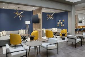 a lobby with tables and chairs and a couch at The Westin Dallas Fort Worth Airport in Irving