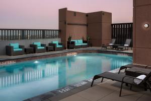 a large swimming pool with lounge chairs and tables at The Westin Dallas Fort Worth Airport in Irving