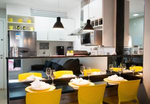 a dining room with yellow chairs and a table with food at GOLDEN LAKE RESIDENCE ARRAIAL DO CABO in Arraial do Cabo