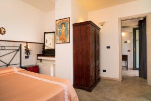 Schlafzimmer mit einem Bett und einem Holzschrank in der Unterkunft Garden Cottage I Dammusi - Limoni in Castelmola
