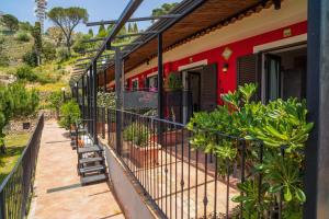 einen Bahnhof mit Zaun und Pflanzen in der Unterkunft Garden Cottage I Dammusi - Limoni in Castelmola