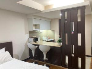a kitchen with a bed and a counter with a microwave at Monolocale Stay (Studio Apartment KBCP) in Kota Bharu