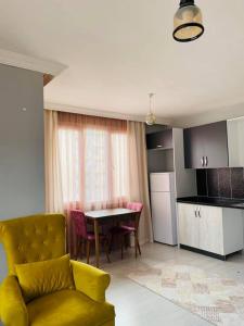 a living room with a yellow couch and a kitchen at palmiye butik otel in Mezitli