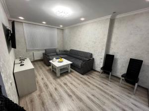 a living room with a couch and a table and chairs at Central Charm Guesthouse in Gyumri