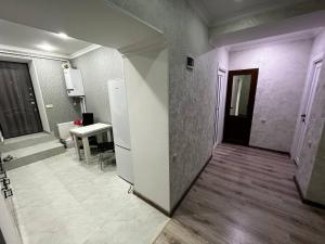 een kamer met een hal met een tafel en een deur bij Central Charm Guesthouse in Gjoemri